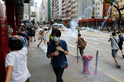 Manifestantes pro-democracia buscan refugio después de que la policía disparara gas lacrimógeno durante una marcha por las calles de Hong Kong en contra del plan de Beijing de imponer una ley de seguridad nacional. REUTERS/Tyrone Siu